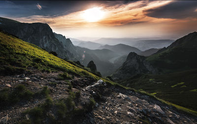 Scenic view of landscape and mountains against cloudy sky