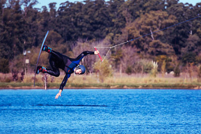 Full length of man wakeboarding in lake