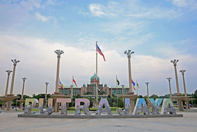 Text with historic building in background against sky