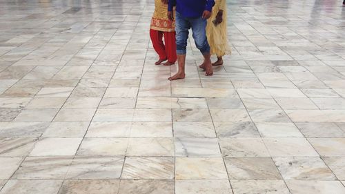 Low section of woman walking on tiled floor