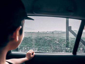 Boy looking through car window