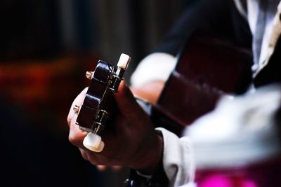 Midsection of man playing guitar