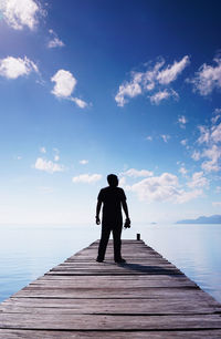 Rear view full length of man standing amidst sea on pier