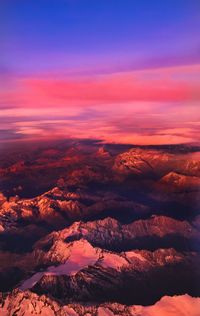 Aerial view of snowcapped mountains against sky during sunset