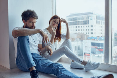 Young couple sitting on window