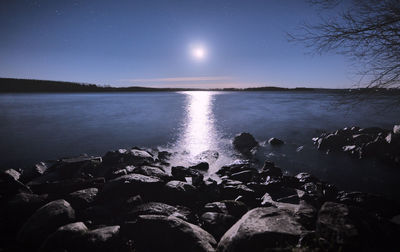 Scenic view of lake against clear sky at night