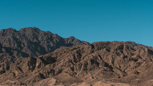 Scenic view of mountains against clear blue sky