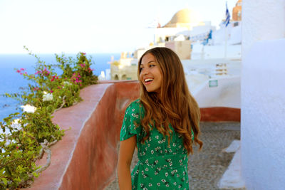 Smiling young woman looking away while standing outdoors