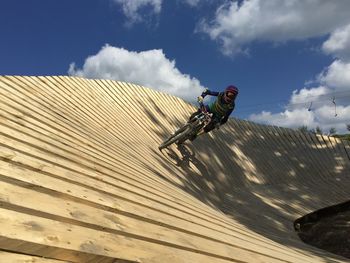 Low angle view of man riding motorcycle against sky