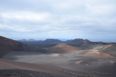 View of volcanic land against sky