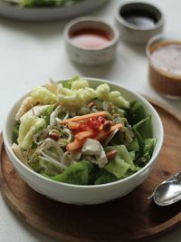 Close-up view of indonesian spicy salad, topped with peanut sauce on the table.