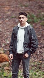 Portrait of young man standing in forest