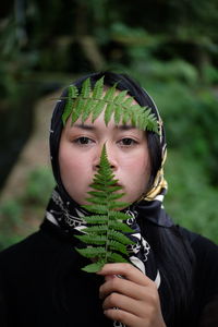 Portrait of man holding leaf outdoors