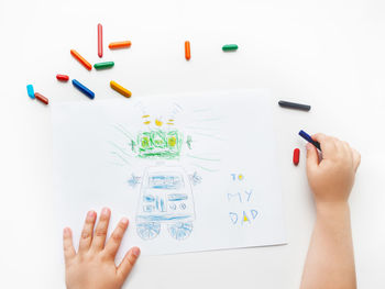 Toddler draws greeting card with funny robot for father's day or daddy's birthday.kid uses crayons. 