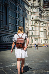 Full length of woman standing against building in city