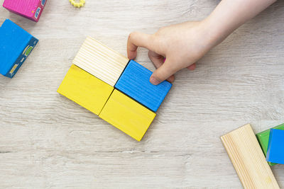 High angle view of woman hand holding multi colored table