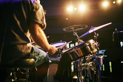 Midsection of man playing drum