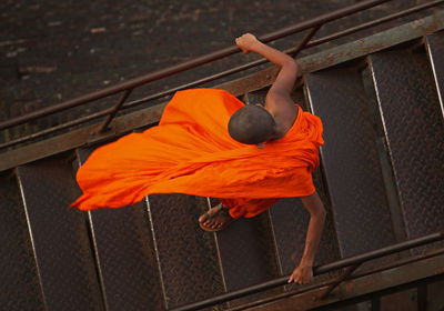 High angle view of monk walking down metallic steps