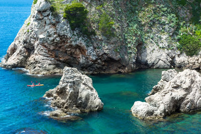 Scenic view of sea by cliff against blue sky