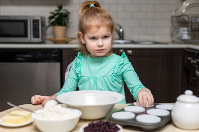 Portrait of cute girl eating food at home