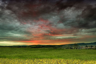 Scenic view of field against dramatic sky