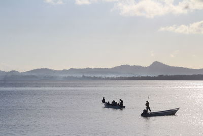 People on sea against sky