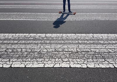 Low section of person skateboarding on road