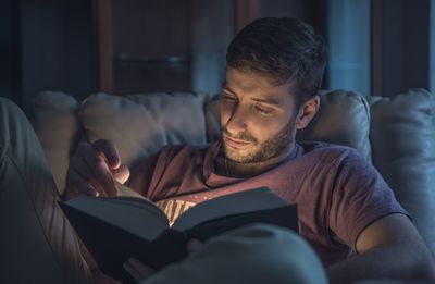 Close-up of mature man sitting on sofa at home