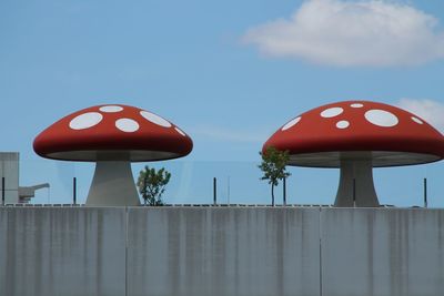 Low angle view of red mushroom shaped structures against sky