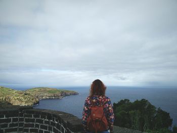 Rear view of woman looking at sea against sky