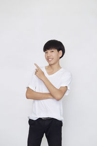 Portrait of young man standing against white background