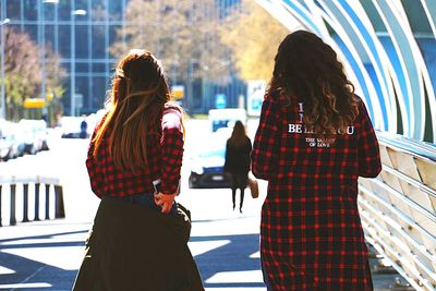 Rear view of couple walking in city during winter