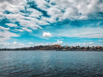 Scenic view of sea by buildings against sky