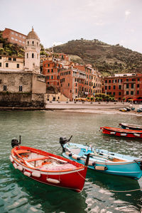 Boats in sea against buildings in city