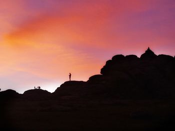 Low angle view of silhouette rock formations against sky during sunset