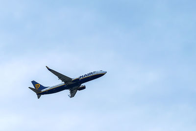 Low angle view of airplane flying against clear blue sky