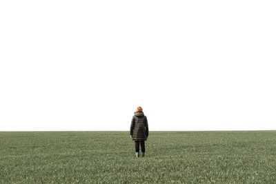 Rear view of person standing on farm against clear sky