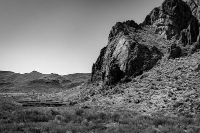 Rock formations on desert landscape against clear sky