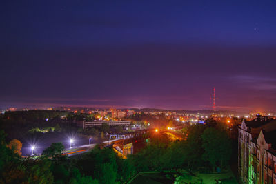 High angle view of illuminated cityscape against sky at sunset