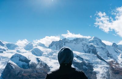 Rear view of man standing on snow covered mountain