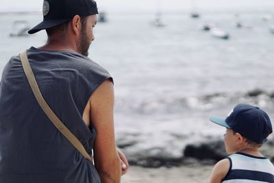 Rear view of a father and son at the beach