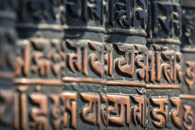 Close-up of text on metal outside temple