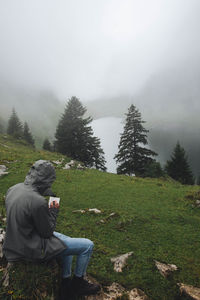 Man on grassy field against sky