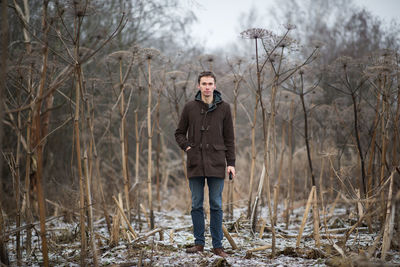 Portrait of young man standing on snow covered land