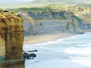 Scenic view of cliff by sea against sky