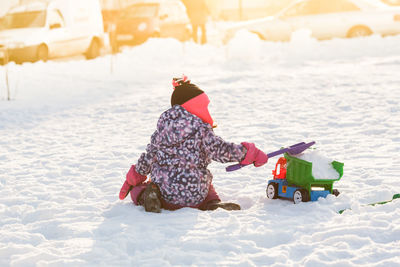 Girl playing on snow covered land