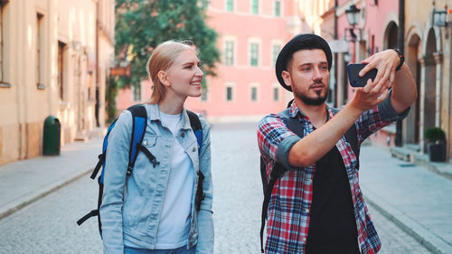 Portrait of smiling friends standing in city