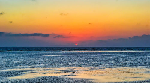 Scenic view of sea against romantic sky at sunset