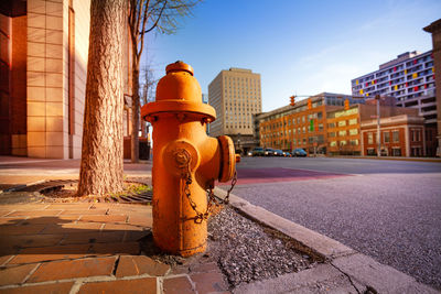 Fire hydrant on street by buildings against sky