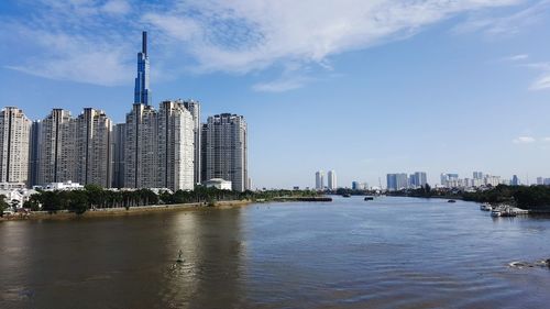 River by buildings against sky in city